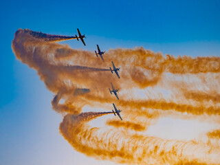 Airshow performance in the warm light of the sunset made by skillful pilots on the skies of...