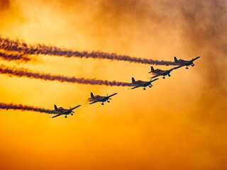 Airshow performance in the warm light of the sunset made by skillful pilots on the skies of Bucharest