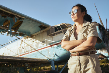 Confident woman by old plane