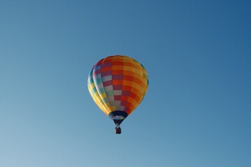 Colorful hot air balloon soaring in a clear blue sky