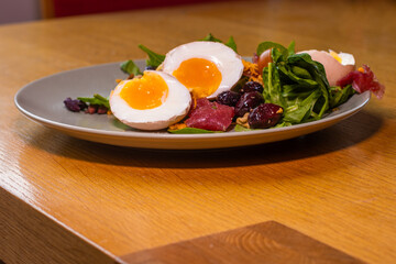 Boiled eggs with spinach, nuts, tomatoes, cheese, seasoned with pepper and salt and drizzled with olive oil.