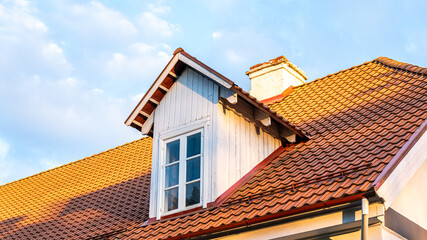 Terracotta roofing tiles on a traditional house, showcasing energy-efficient design, durable construction, and beautiful aesthetics under a clear blue sky with copy space