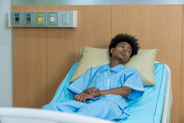 A sick person is lying in a hospital room. A man lying sick in hospital.