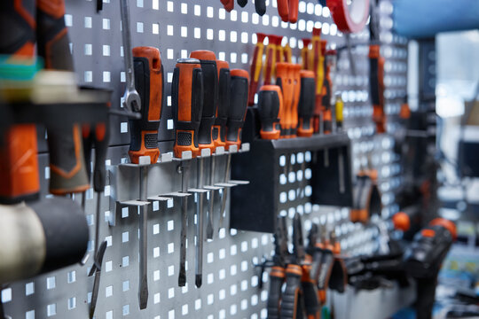 A collection of various tools is hanging on an organized wall