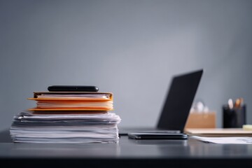 close-up of a desk in an office with documents, a laptop, and a phone on it, against a gray background, minimalistic style.