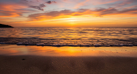 Obraz premium Scenic Beach Sunset with Golden Horizon and Reflective Water on Tranquil Sandy Shore
