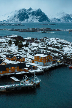 Snowy Coastal Village with Orange Houses and Boats