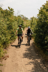 Cyclists enjoying an outdoor trail surrounded by nature, trees, and natural surroundings