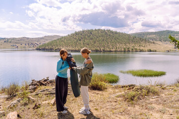 Fototapeta premium Two women enjoying a lakeside moment in a serene landscape