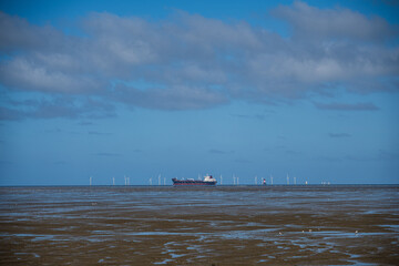 Frachtschiff vor einer Offshoreanlage in der Nordsee