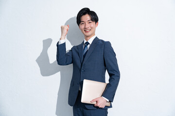 ガッツポーズをするスーツを着た若い日本人男性