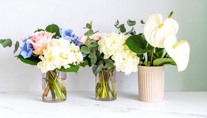 Three floral arrangements in glass vases