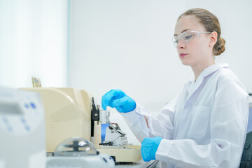 A medical lab scientist places a sample tube into a small centrifuge, an important step in...
