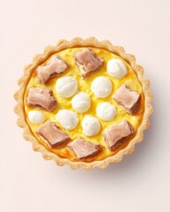 A delicious savory pie featuring golden crust, chunks of ham, and dollops of cream on a creamy custard base.
