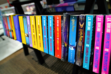 Naklejka premium Minsk, Belarus. Jan 12, 2025. English editions of Harry Potter novels written by J.K. Rowling arranged on bookshelf inside bookstore, literature display for fans of fantasy adventures. Selective focus
