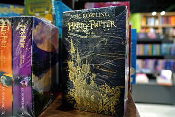 Naklejka premium Minsk, Belarus. Jan 12, 2025. English editions of Harry Potter and Deathly Hallows novel written by J.K. Rowling on bookshelf, literature display for fans of fantasy adventures. Selective focus