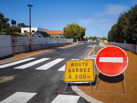 Sinal de tr&acirc;nsito com a descri&ccedil;&atilde;o em franc&ecirc;s de estrada cortada a 900 metros e outro de sentido proibido numa rua suburbana em Fran&ccedil;a