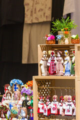 A vibrant display of traditional Ukrainian dolls is arranged on a wooden stand. Each doll carries unique patterns, flowers, and vibrant fabrics that reflect folk heritage.