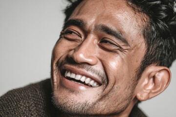 Fototapeta premium Smiling man expresses joy and happiness indoors during a bright afternoon in casual attire