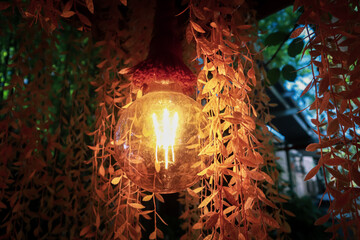 A warm-toned round bulb surrounded by hanging leaves creates a warm and relaxing atmosphere.