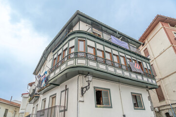 Obraz premium White Facade Building With Green Trim And Balcony In Bermeo Basque Country Spain. Coastal fishing town, travel destination, historic charm