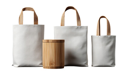 Three white canvas tote bags of varying sizes, alongside a cylindrical wooden container