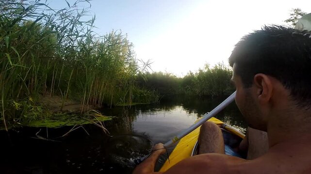 Kayaker paddling through serene waters, showcasing dynamic movement and interaction with nature, as sunlight filters through lush greenery, creating a tranquil outdoor adventure experience