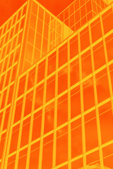 Modern glass building with an intense orange filter, creating a bold and abstract architectural effect
