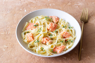 Pasta fettuccine in a creamy sauce with salmon, cheese and thyme. Italian cuisine. Healthy eating.