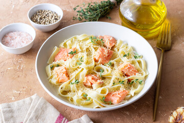 Pasta fettuccine in a creamy sauce with salmon, cheese and thyme. Italian cuisine. Healthy eating.