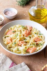 Pasta fettuccine in a creamy sauce with salmon, cheese and thyme. Italian cuisine. Healthy eating.