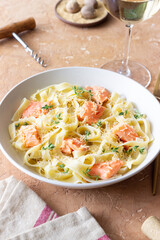 Pasta fettuccine in a creamy sauce with salmon, cheese and thyme. Italian cuisine. Healthy eating.
