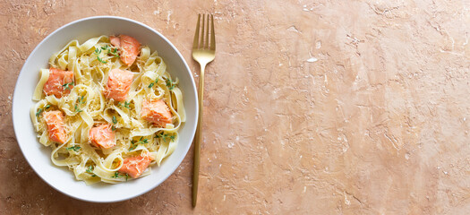 Pasta fettuccine in a creamy sauce with salmon, cheese and thyme. Italian cuisine. Healthy eating.