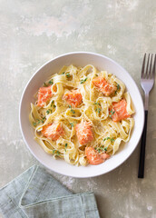Pasta fettuccine in a creamy sauce with salmon, cheese and thyme. Italian cuisine. Healthy eating.