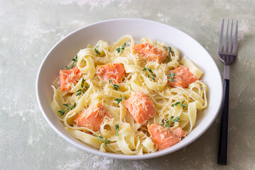 Pasta fettuccine in a creamy sauce with salmon, cheese and thyme. Italian cuisine. Healthy eating.
