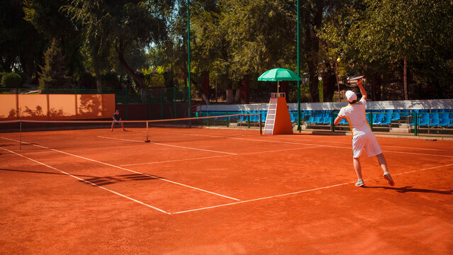 Tennis player serving on clay court - Powered by Adobe