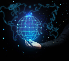 a man's hand holds a holographic globe on a dark blue background. Concept of globalization, world...