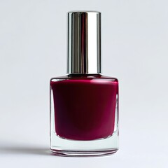 A bottle of deep crimson nail polish with a silver cap, set against a bright white background