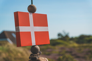 Wooden Danish flag hanging with beads against blue sky, Denmark