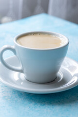  Large White Cup of Milky Coffee on a Blue Background