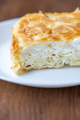Traditional Turkish Cheese “Su Böreği” on a White Plate on a Brown Table