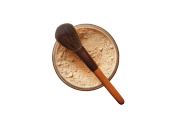 Light beige powder in a glass jar with a makeup brush
