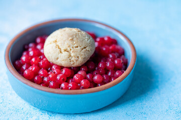 Red Currants and a Fresh Homemade Cookie in a Blue Bowl on a Blue Background