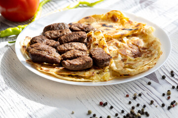 Close-Up of Romanian Mici Sausages Served with Flatbread and Tomatoes on a White Plate

