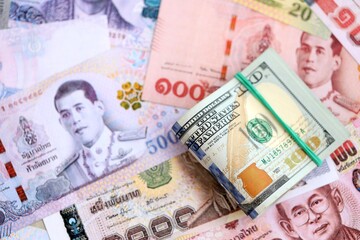 Thai baht currency money bills and bunch of us dollars. The concept of currency exchange