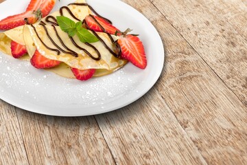 Crepes, tasty pancakes on plate with berries