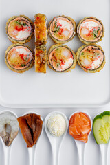Baked sushi roll with salmon close-up on a white background isolated