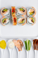 Salmon sushi roll with ingredients on a white background isolated