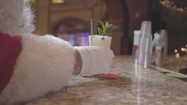 A bartender slides a drink to Santa Claus in festive setting. Ideal for holiday celebrations, Christmas parties, bartending, drinks service, and seasonal event themes.