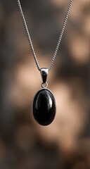 Polished black oval gemstone pendant on a delicate chain
